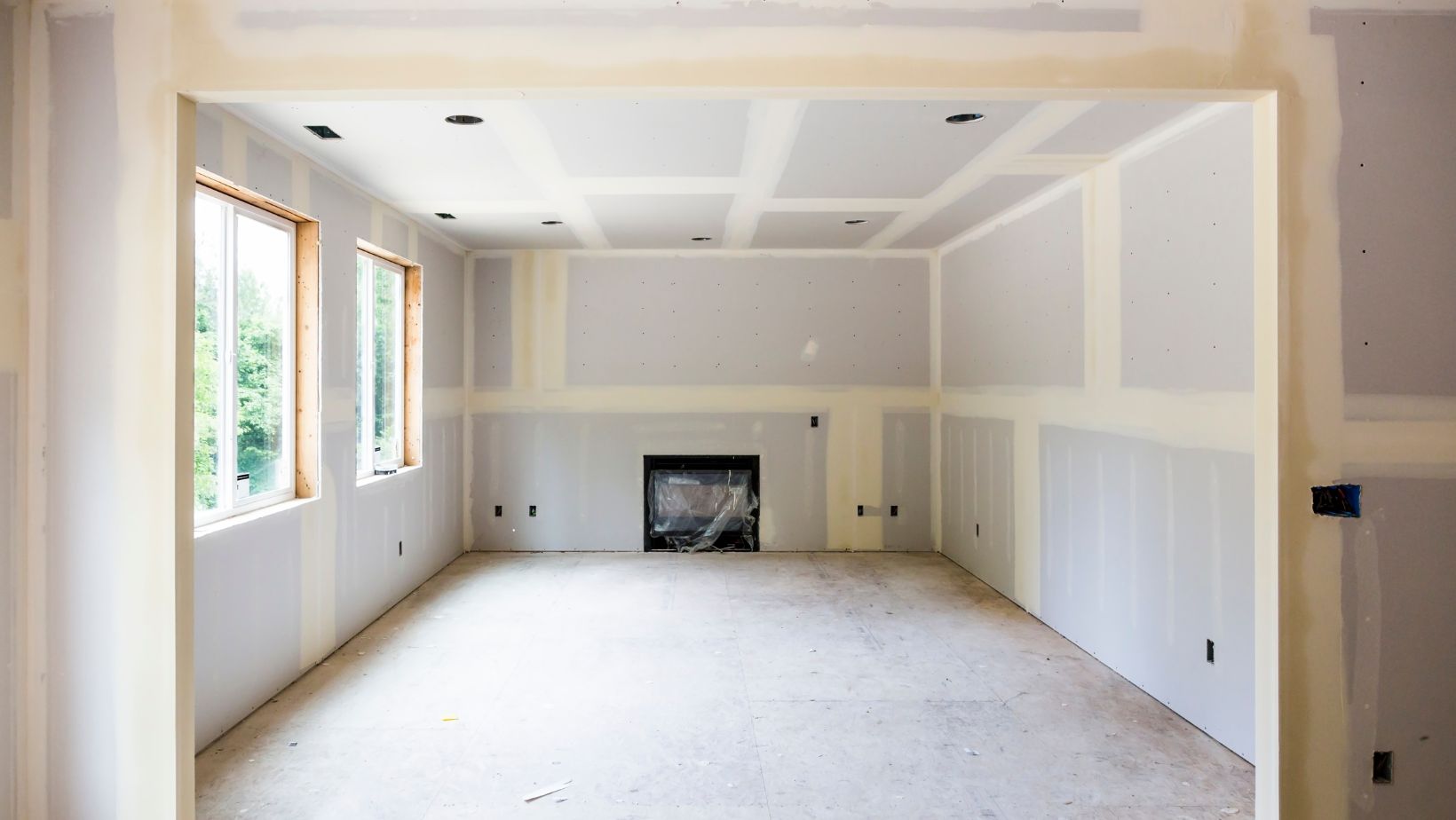 Text: Professional drywall services – newly installed drywall in a residential home, ready for finishing.