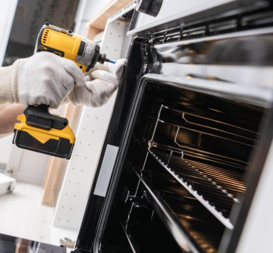 Expert Gas Appliances Installation. Professional gas oven installation – expert technician securing and aligning a built-in gas appliance.