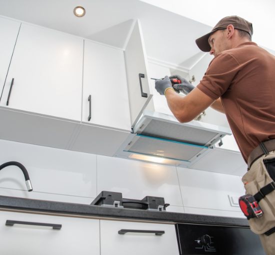 Professional kitchen remodeling services in Birmingham, Alabama – expert contractor installing a range hood.